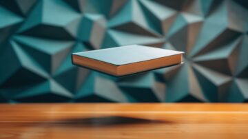 كتاب مع غلاف أزرق يطفو فوق سطح خشبي، مع خلفية مكونة من أشكال هندسية ثلاثية الأبعاد باللون الأزرق.