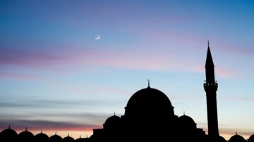 Minimalist mosque silhouette under a crescent moon in a deep blue sky, representing the peace and oneness of Understanding Tawhid.