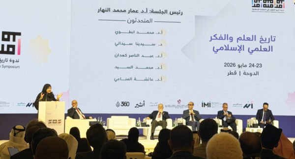 مؤتمر علمي في قطر حول تاريخ العلم والفكر العلمي الإسلامي، يتضمن متحدثين بارزين على المنصة. خلفية تتضمن شعار المؤتمر، مع جمهور يتابع الجلسة.
