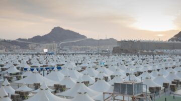 خيام بيضاء منسقة في مشعر منى خلال غروب الشمس