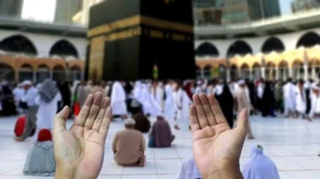 Mains levées en prière devant la Kaaba, avec des pèlerins en arrière-plan lors du Hajj à La Mecque. L'image capture l'esprit de dévotion et la spiritualité de ce lieu sacré.