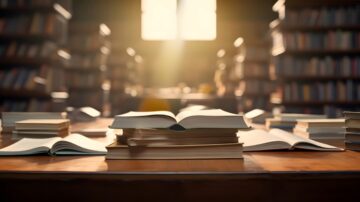مكتب مليء بالكتب المفتوحة والمغلفة، مع ضوء الشمس يتسلل من النوافذ. الأرفف في الخلفية تحتوي على مزيد من الكتب، مما يخلق جوًا هادئًا ومناسبًا للدراسة.