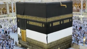 La Kaaba, bâtiment cubique sacré de La Mecque, entourée de pèlerins en tenue traditionnelle blanche, lors du Hajj. Les ornements dorés sur la couverture noire de la Kaaba sont visibles. L'atmosphère est spirituelle et rassembleuse.