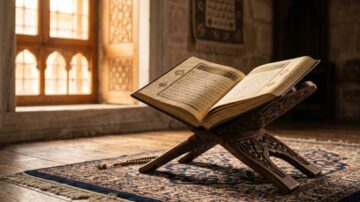 قرآن مفتوح على حامل خشبي يعكس أجواء التأمل في قوله تعالى تلك أمة قد خلت، يقع على سجادة تقليدية مع نافذة مضاءة في الخلفية تبرز التصميم المعماري الإسلامي والأجواء الروحية.