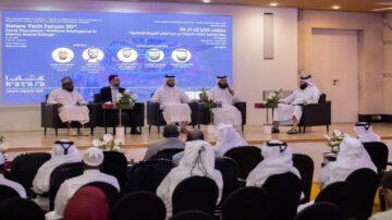 منتدى كتارا للتكنولوجيا 30 يتضمن نقاشًا حول الذكاء الاصطناعي في تصنيفات الشريعة الإسلامية، مع خمسة متحدثين يجلسون على المنصة أمام شاشة عرض كبيرة. الجمهور يتابع الحوار في قاعة مجهزة بشكل حديث.