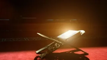 Livre sacré sur un support en bois, éclairé par une lumière douce, sur un tapis rouge. Ambiance calme et spirituelle.