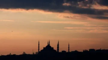 Silhouette d'une mosquée avec plusieurs minarets sous un ciel nuageux au crépuscule, mettant en valeur les contours architecturaux et l'ambiance paisible d'Istanbul.