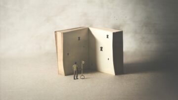 رجل صغير يقف أمام كتاب مفتوح، حيث تظهر على صفحات الكتاب أقفال مفاتيح، مما يرمز إلى الاكتشاف والمعرفة.
