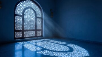 Intricately designed window casting patterned shadows on a marble floor, illuminated by soft beams of light in a serene, blue-toned room, symbolizing tranquility and mental health in Islam