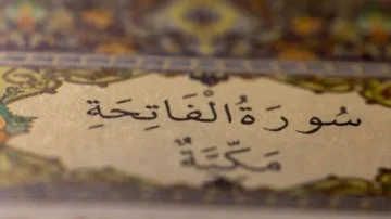 Texte arabe de la Sourate Al-Fatiha, ornée de motifs décoratifs, mettant en avant la calligraphie et l'esthétique du Coran.