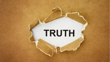 Un morceau de papier déchiré laissant apparaître le mot "TRUTH" (vérité) sur un fond marron.