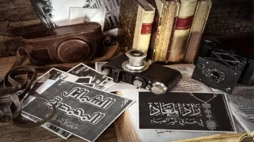 Composition vintage avec un appareil photo ancien, des livres, des cartes postales et des accessoires photographiques sur une table en bois. Les éléments évoquent l'histoire de la photographie et le patrimoine culturel.