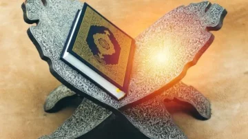 Livre sacré ouvert sur un support en bois décoré, avec un éclairage doux. Idéal pour illustrer la lecture religieuse et la culture islamique.