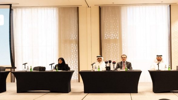 مؤتمر صحفي يتضمن أربعة متحدثين يجلسون خلف مكاتب مرتبة. المتحدثة الأولى ترتدي حجاباً وتجلس على اليسار، بينما يتوسط رجلان يرتديان بدلات رسمية. يوجد ميكروفونات وزجاجات ماء على المكاتب، مع خلفية تحتوي على نوافذ كبيرة تسمح بدخول الضوء الطبيعي.